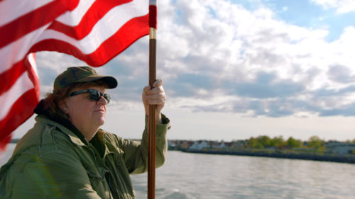 Michael Moore heiluttaa tähtilippua liberaalin USA:n puolesta