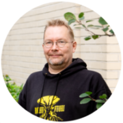 Rantanen katsoo hymyillen kameraan. Taustalla vaalea seinä ja kaupunkiluontoa.