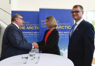 Timo Soini kättelemässä Federica Mogherinia. Juha Sipilä katsoo kohti kameraa ja hymyilee.