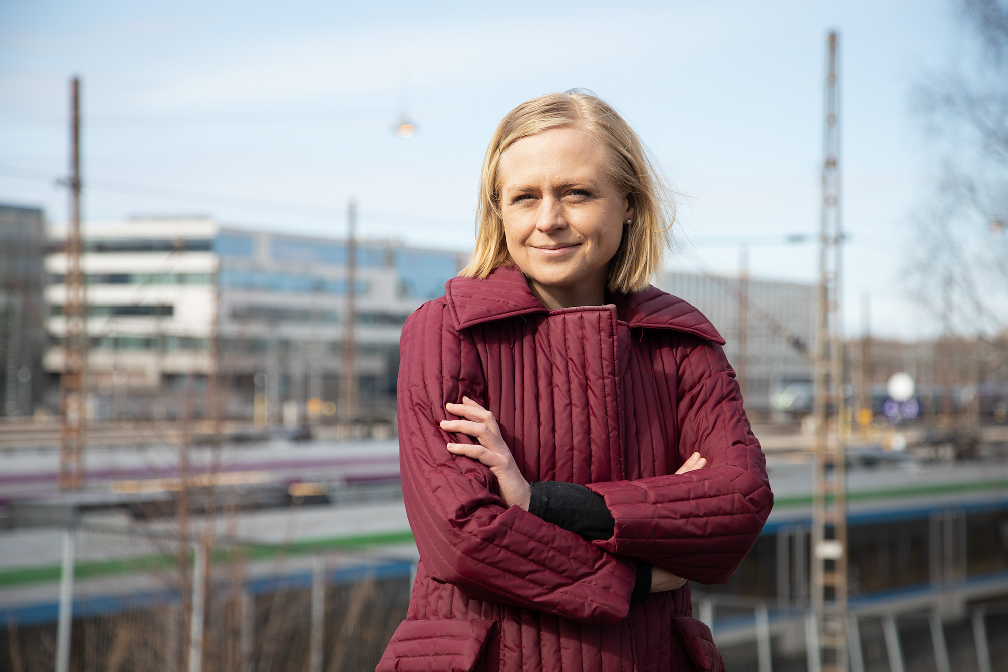 Lepomäki katsoo kameraan hymyillen, taustalla Helsingin rautatieaseman ympäristöä.
