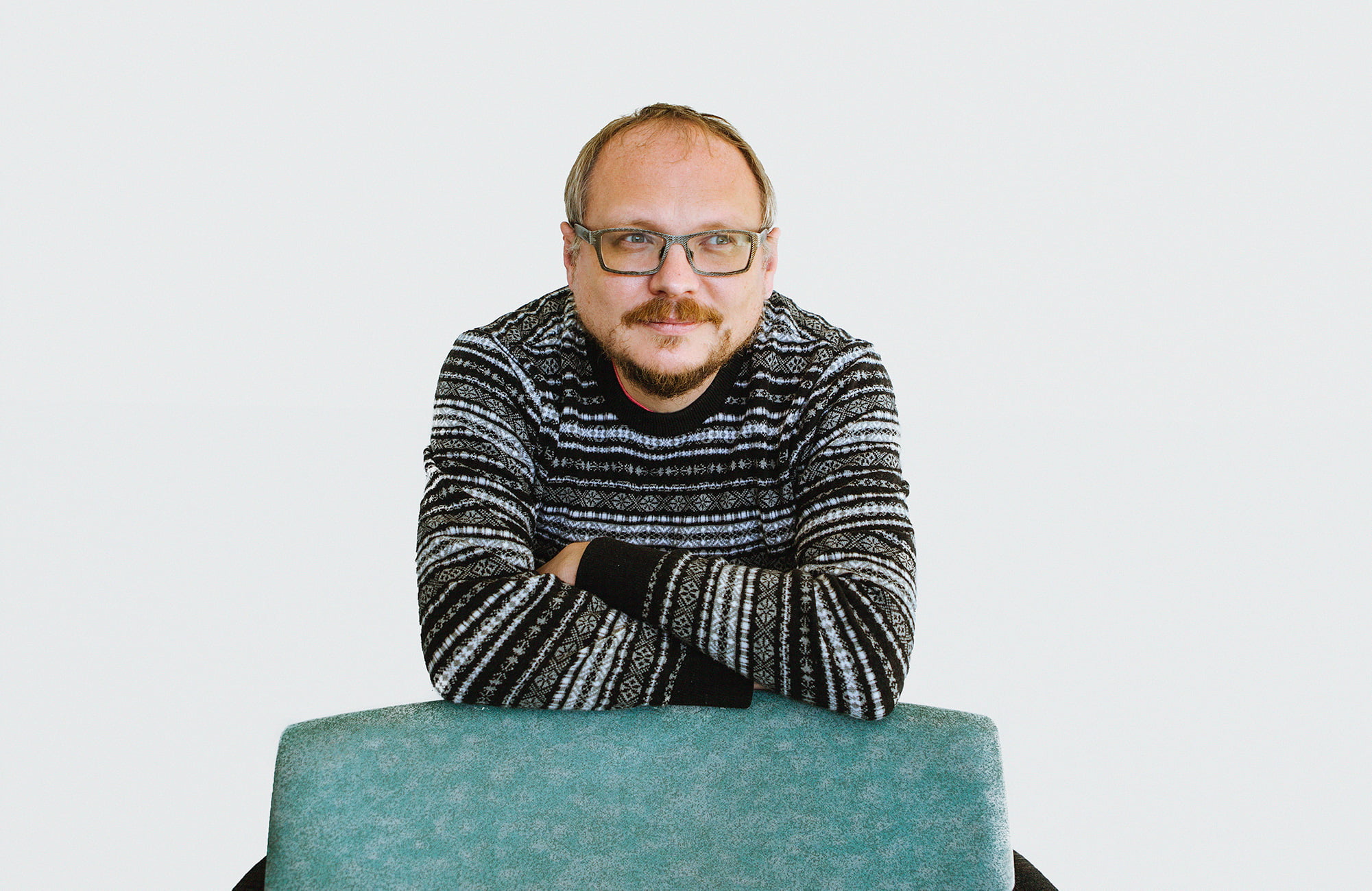 Andrei Kureichik katsoo pois kamerasta, nojaa tuolin selkämykseen.