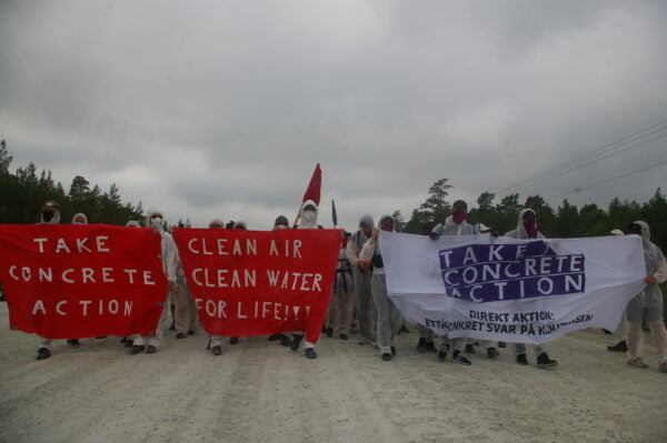 Mielenosoittajat marssivat rivissä, lakanoissa lukee mm. "Clean air, clean water for life!".