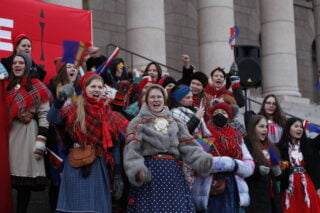 Mielenosoittajia Eduskuntatalon portailla.