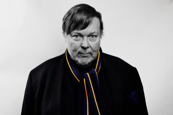 Mustavalkoinen valokuva Markus Leikolasta, kaulahuivi sini-keltainen.
