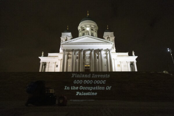 Teksti “Finland Invests 400 000 000 € in the Occupation of Palestine” heijastettu Tuomiokirkon portaille.