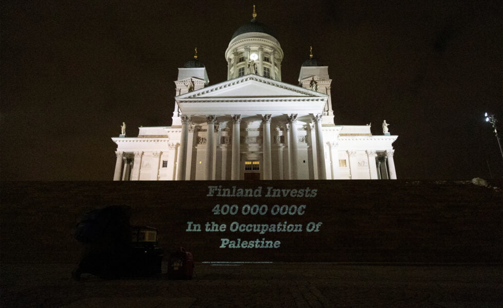 Teksti “Finland Invests 400 000 000 € in the Occupation of Palestine” heijastettu Tuomiokirkon portaille.