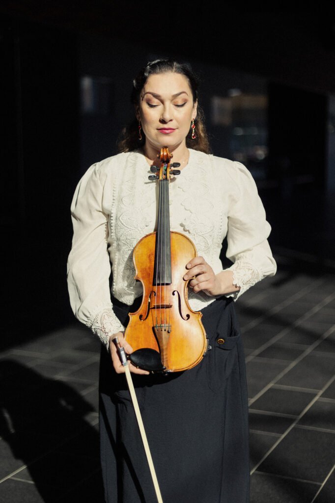 Miritza Lundberg pitelee viulua edessään, katsoo sitä. 