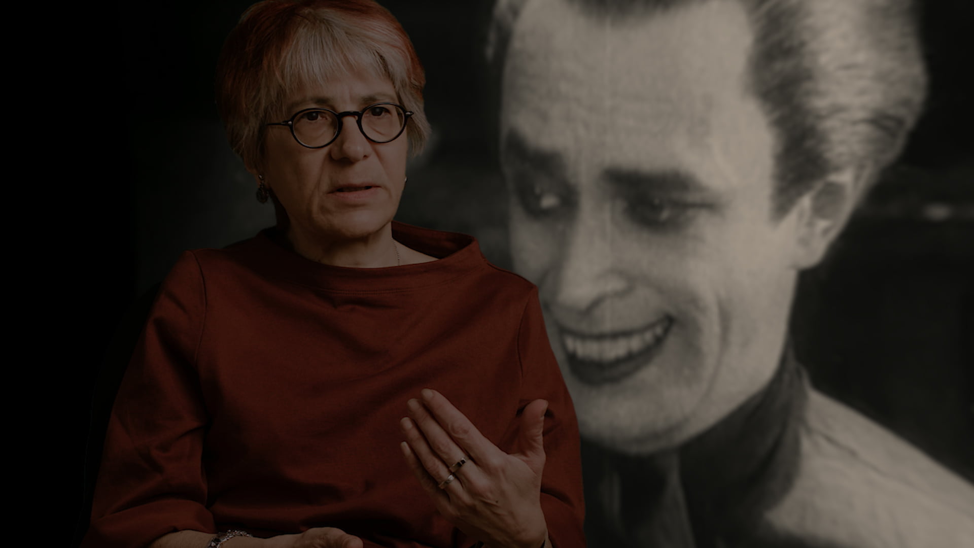 Etualalla puhuva henkilö ja takana still-kuva elokuvasta Freaks