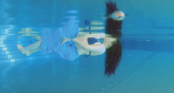 Uima-altaassa kelluva nainen alhaalta sivusta kuvattuna