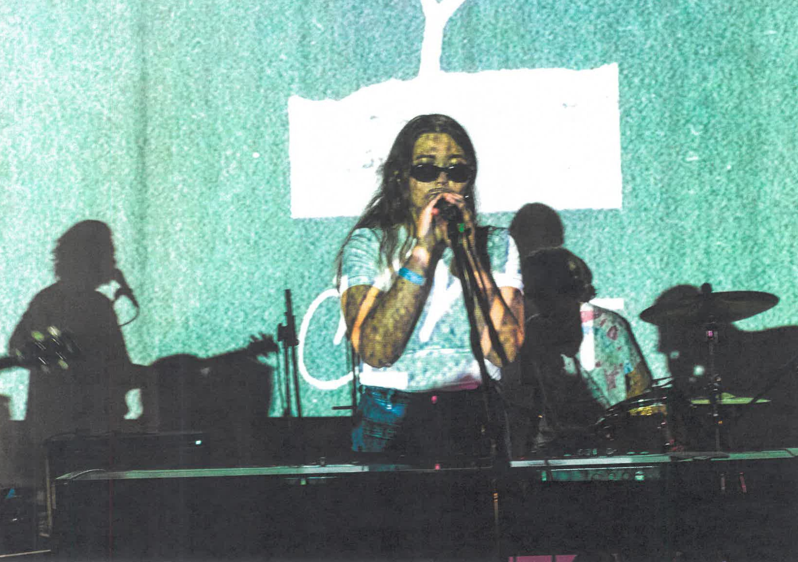 Ocelot yhtye soittaa. Bändin ylle heijastuu graafisia elementtejä videotykistä.