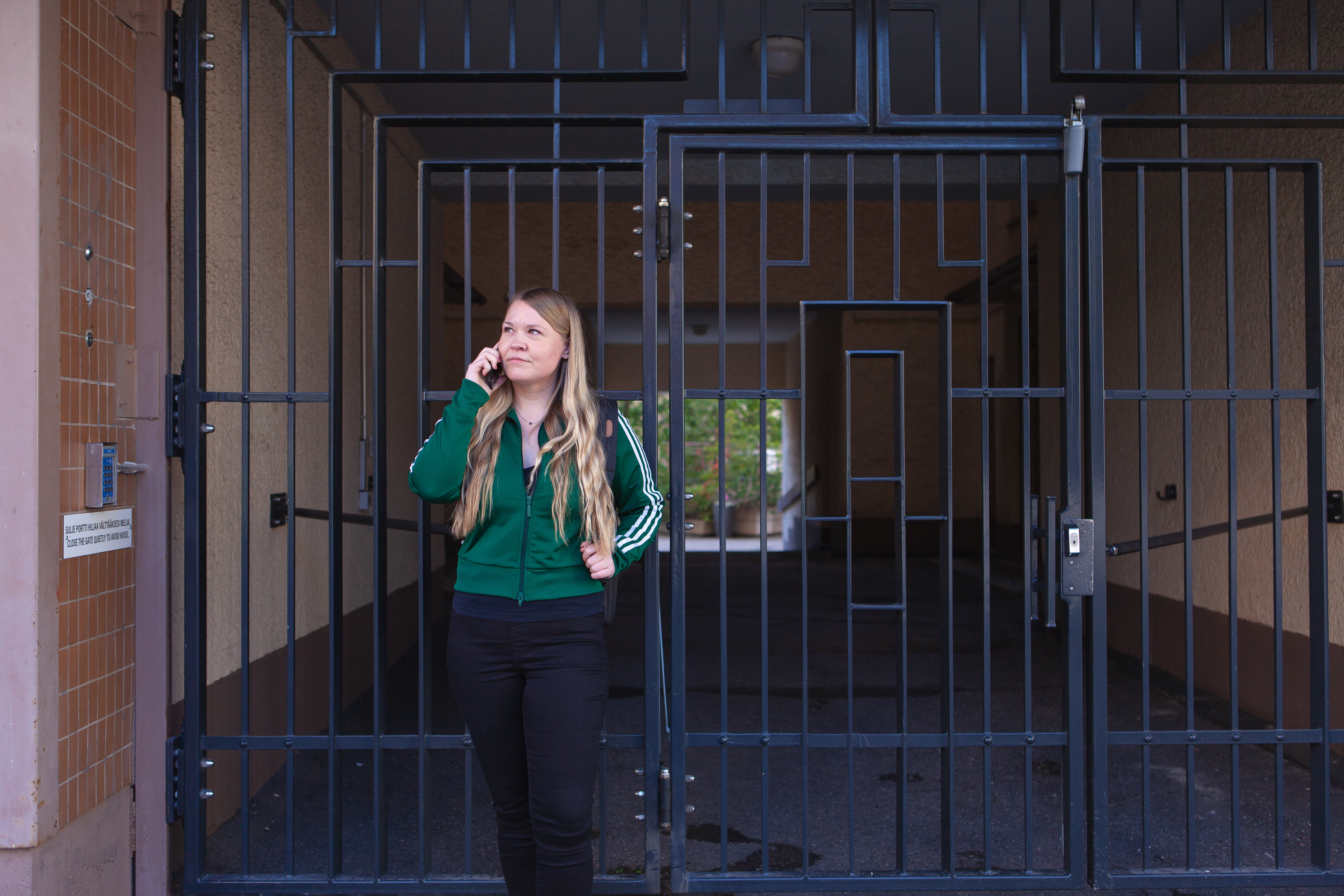 Niina Holma seisoo portin edessä, puhuu puhelimeen.