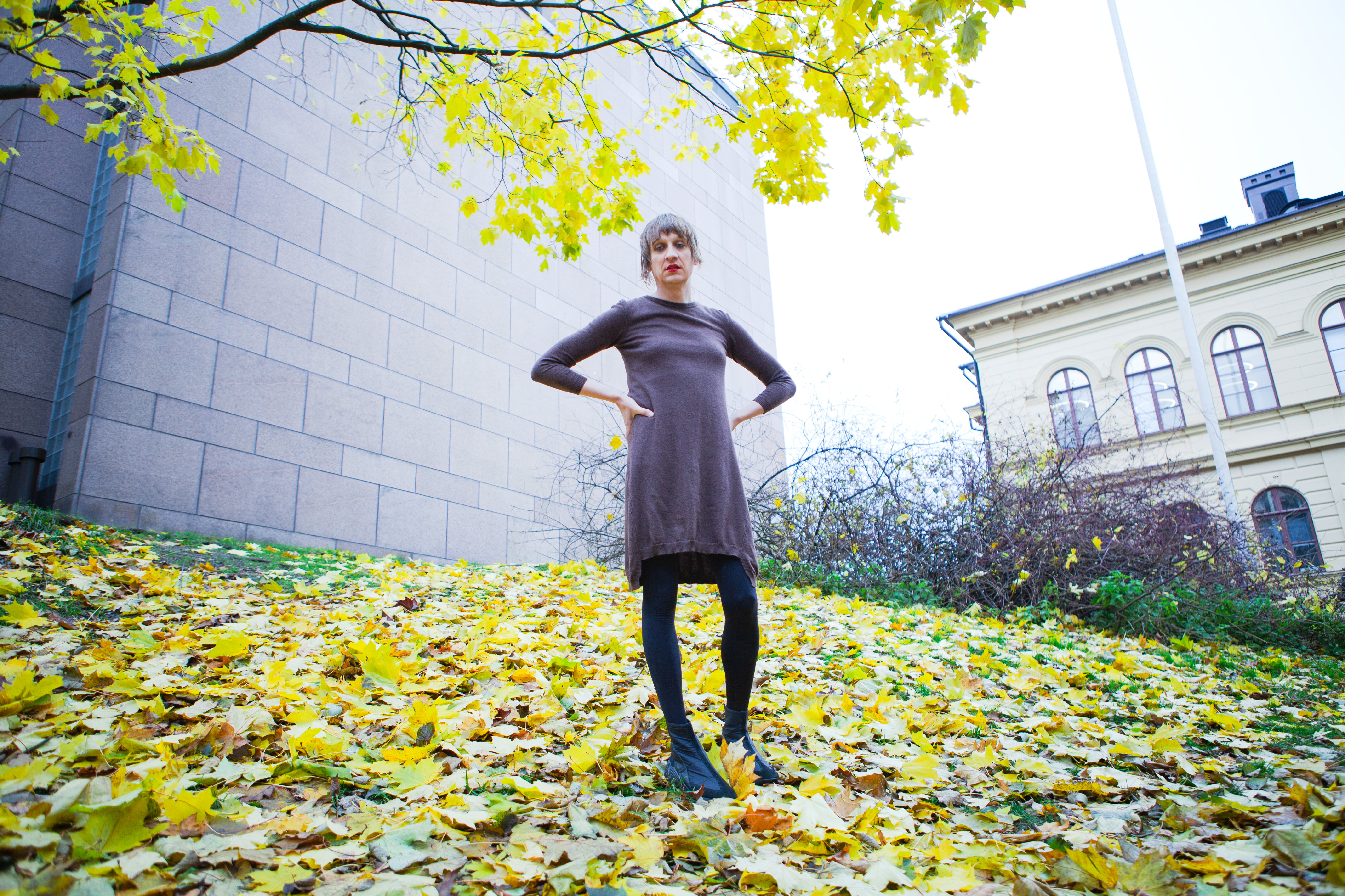 Kaino Wennerstrand seisoo ulkona, maassa keltaisia lehtiä.