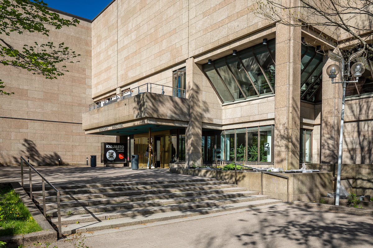 Kirjaston julkisivu aurikoisena kesäpäivänä