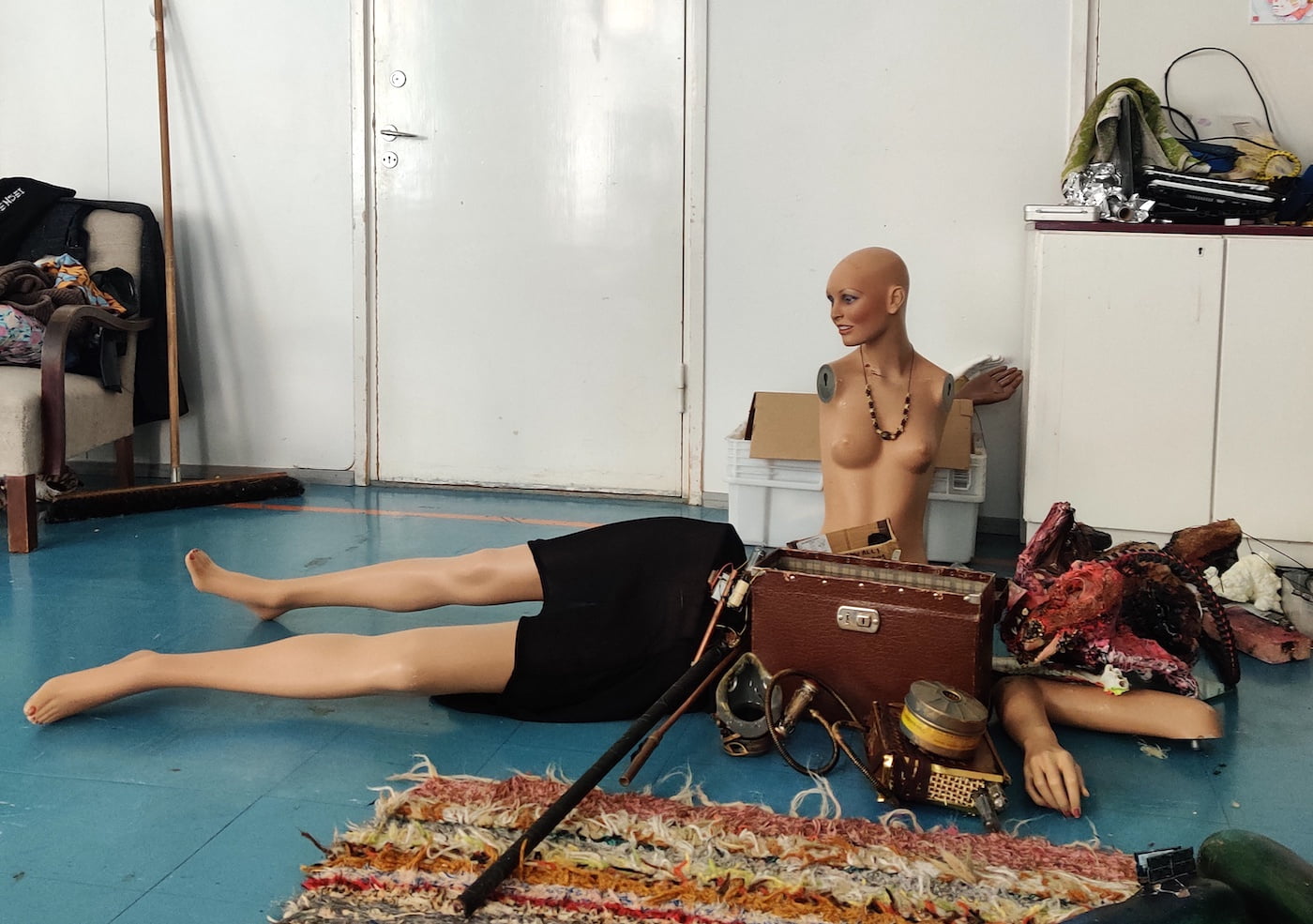 Taidetarvikkeita ja mallinukkeja lattialla