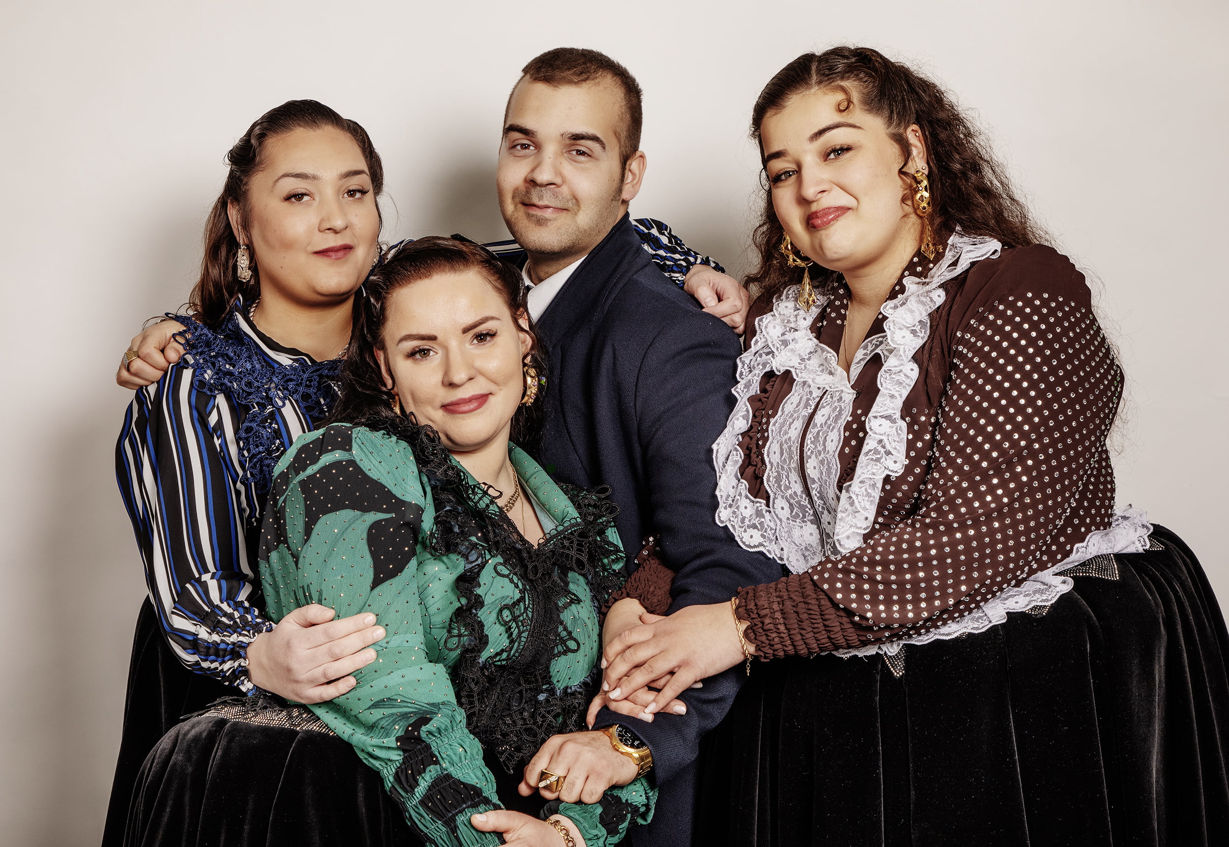 Neljä romania poseeraa kameralle kansallispuvuissaan.