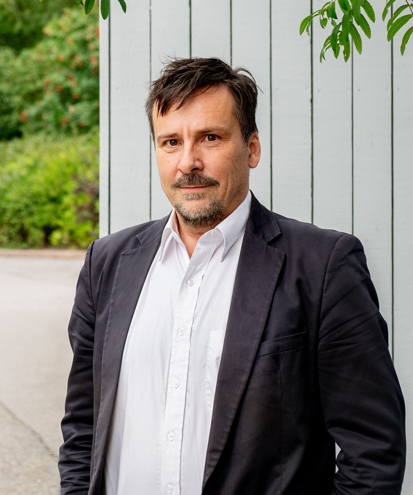 Matinpuro katsoo kameraan, taustalla seinä ja kaupunkiluontoa.