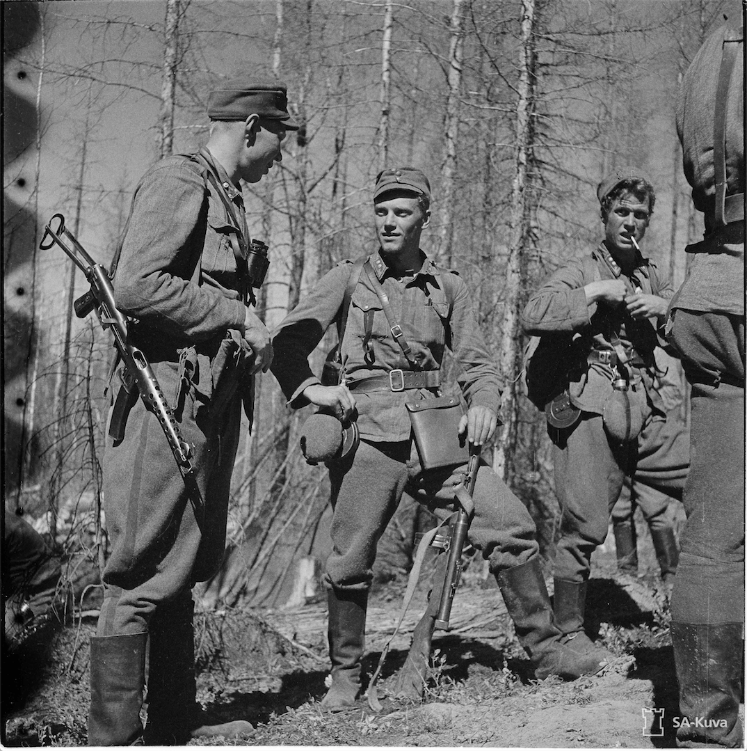 Kolme huimapäätä ja kovien taistelujen karaisemaa upseeria neuvottelussa vastaiskun jälkeen. Kuvassa vasemmalla kapteeni Railio JR 33, keskellä Mannerheim-ristin ritari luutnantti Törni, Jääkärikomppanian päällikkö, ja oikealla edellisen ”adjutantti” luut- nantti Pitkänen. Tolvajärven pohjoispuoli 27.7.1944. KUVA: SA-KUVA