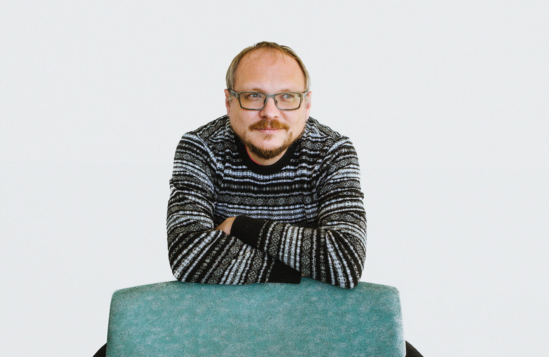 Andrei Kureichik katsoo pois kamerasta, nojaa tuolin selkämykseen.