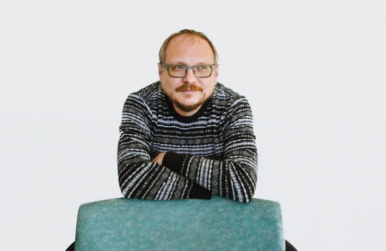 Andrei Kureichik katsoo pois kamerasta, nojaa tuolin selkämykseen.