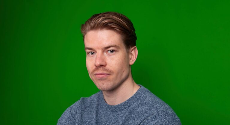 Anton Hämäläinen katsoo kameraan, vihreä tausta.