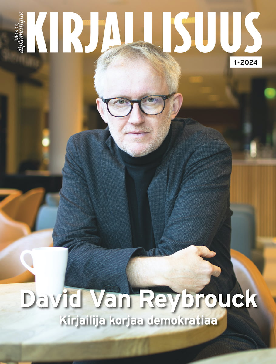 Kirjallisuus-liitteen kansi jossa David van Reybrouck nojaa pöytään