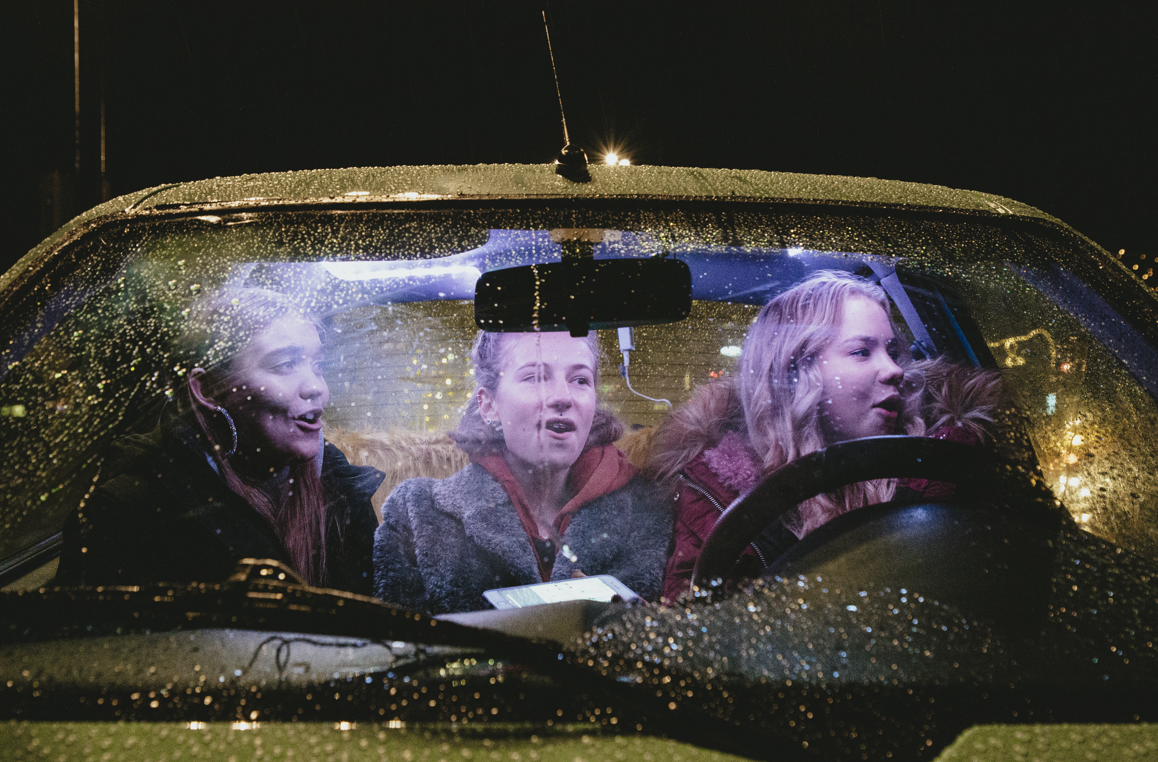 Kolme teini-ikäistä autossa.