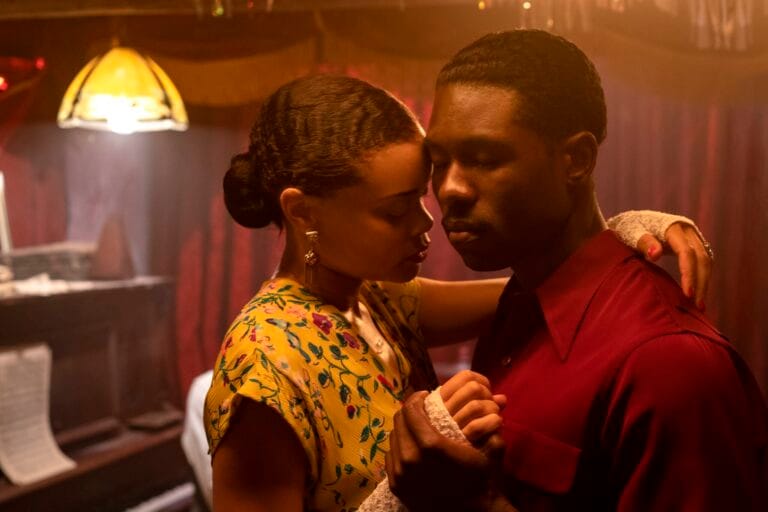 Andra Day ja Trevante Rhodes tanssivat sisätilassa lämpimässä valossa lähekkäin, silmät kiiinni.