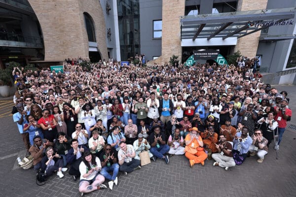 Wikimania_2025_group_photo_with_participants_forming_a_%22W%22_shape_with_their_hands